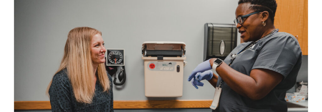 Patient and provider having a discussion in an exam room